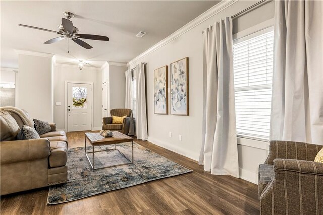 living area featuring a ceiling fan, baseboards, crown molding, and wood finished floors