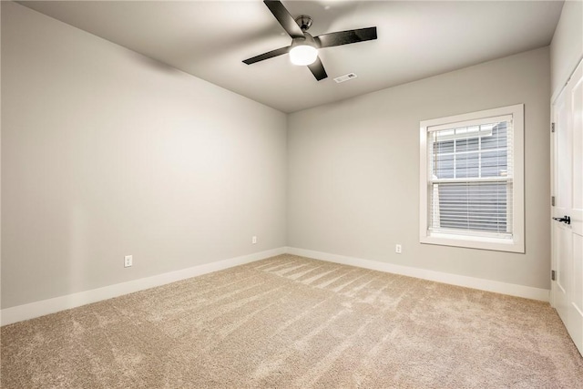 empty room with baseboards, visible vents, and light colored carpet