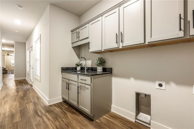 washroom featuring dark wood-style floors, cabinet space, a sink, and electric dryer hookup