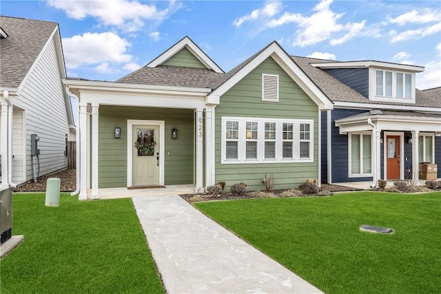 view of front facade featuring a front yard and roof with shingles