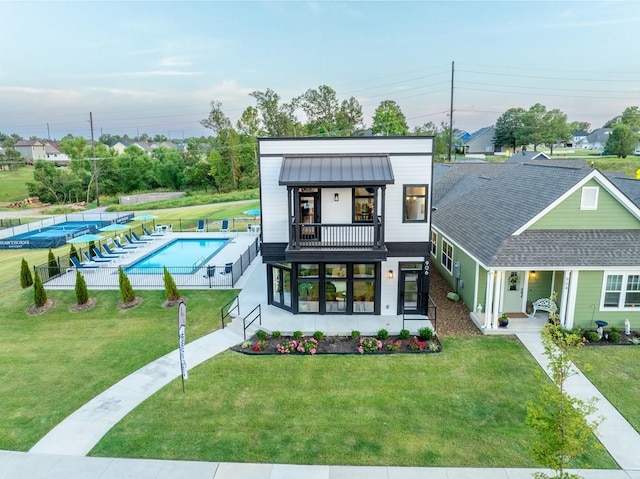 exterior space with a fenced in pool, a lawn, a standing seam roof, a patio area, and fence