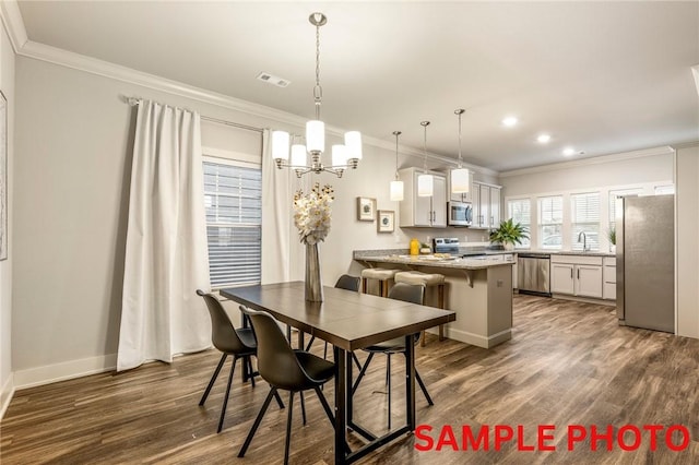 dining space with baseboards, visible vents, dark wood-style floors, ornamental molding, and an inviting chandelier