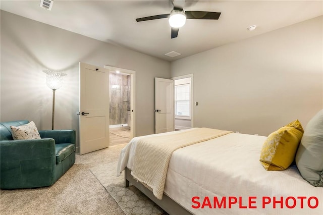 carpeted bedroom with visible vents, ceiling fan, and ensuite bath