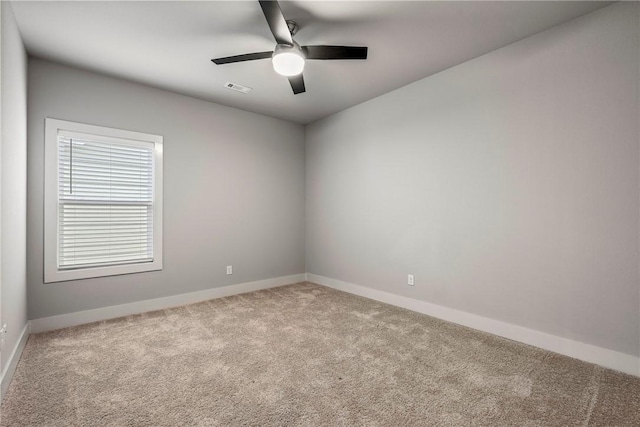 spare room with carpet floors, baseboards, visible vents, and ceiling fan