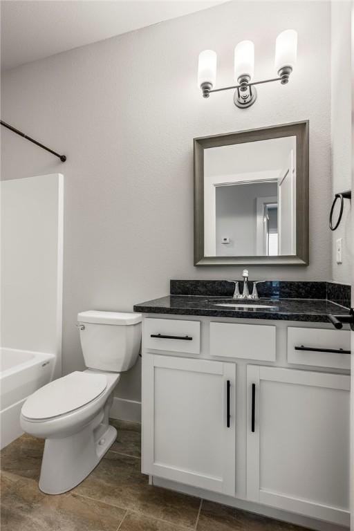 full bath with washtub / shower combination, baseboards, vanity, and toilet