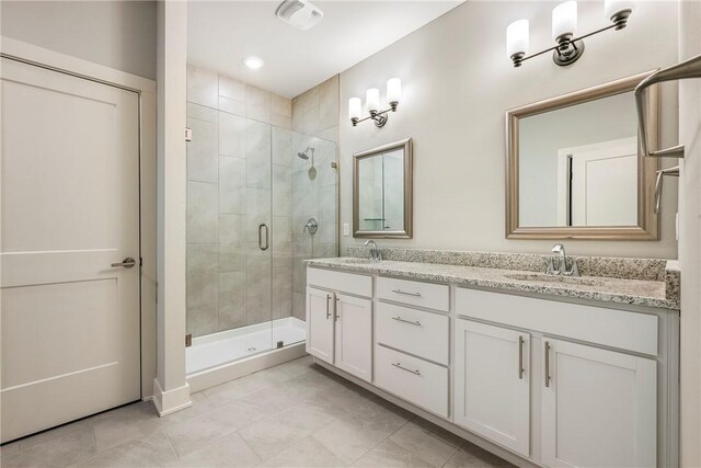 full bath with a shower stall, double vanity, visible vents, and a sink