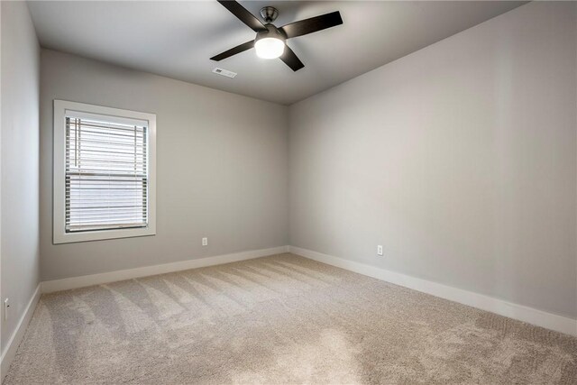 carpeted empty room featuring a ceiling fan, baseboards, and visible vents