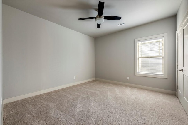 spare room with visible vents, baseboards, and light colored carpet