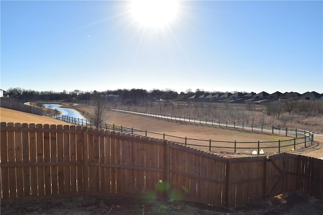 view of yard featuring a water view and fence