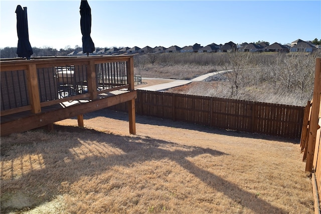 view of yard featuring a residential view, fence, and a wooden deck