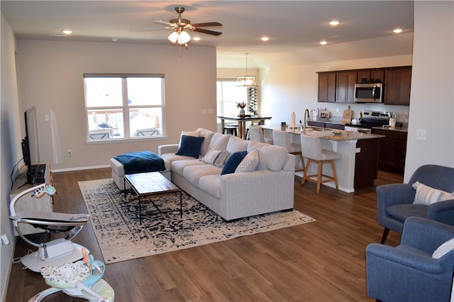 living area with dark wood-type flooring and recessed lighting