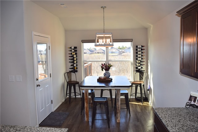 dining space with dark wood-type flooring, visible vents, and vaulted ceiling