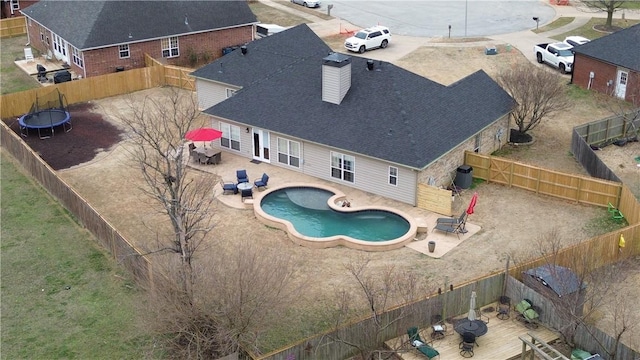 view of pool with central air condition unit, a patio area, a fenced backyard, and a trampoline