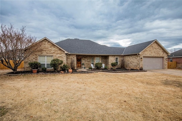 ranch-style house with a garage, brick siding, concrete driveway, roof with shingles, and a front yard