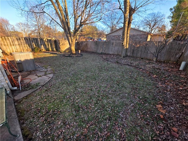 view of yard with a fenced backyard and central AC unit