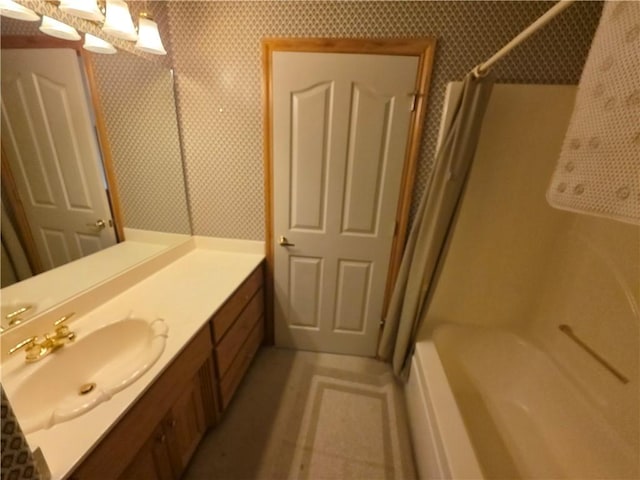 full bathroom featuring wallpapered walls and vanity