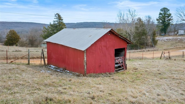 view of pole building with a rural view and fence