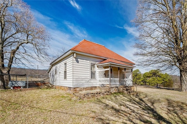 exterior space with covered porch, a lawn, and fence