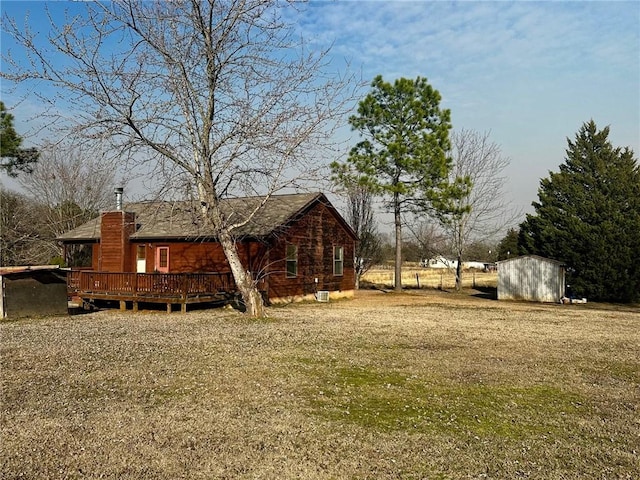 view of yard with a shed, a deck, and an outdoor structure