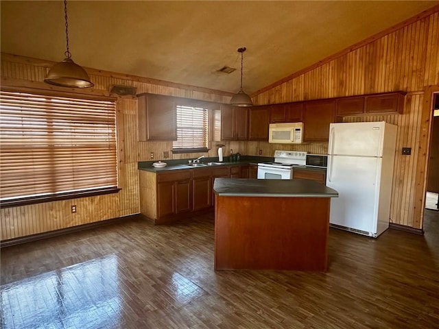 kitchen with lofted ceiling, white appliances, a kitchen island, a sink, and dark countertops