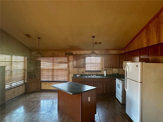 kitchen with a kitchen island, white appliances, vaulted ceiling, and a sink