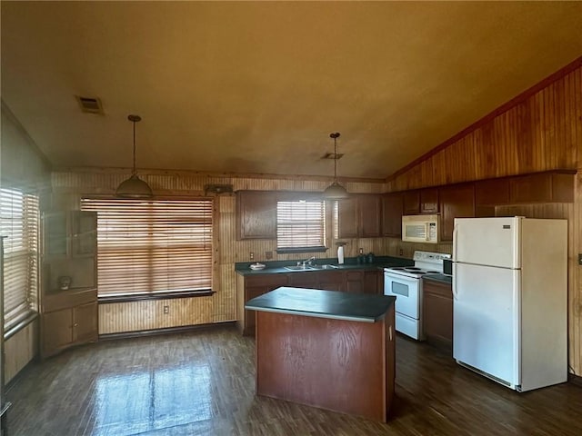 kitchen with white appliances, a sink, vaulted ceiling, a center island, and dark wood finished floors