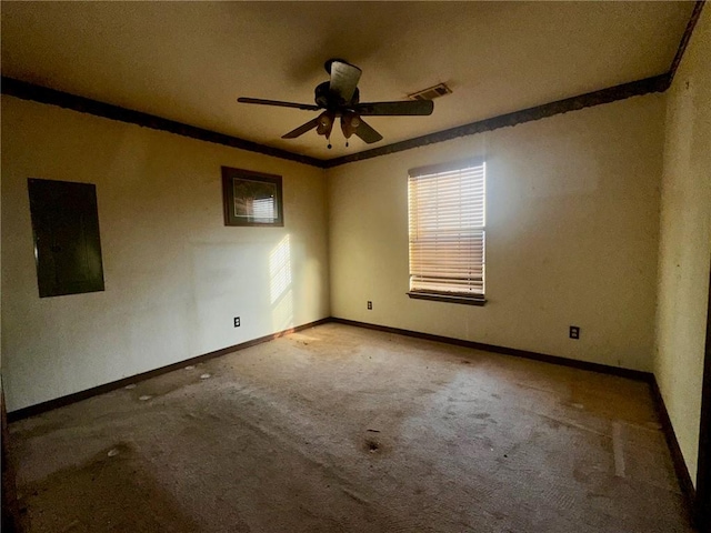 carpeted empty room featuring crown molding, a ceiling fan, visible vents, and a healthy amount of sunlight