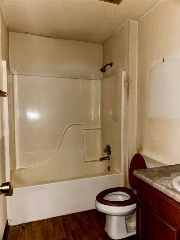 bathroom with vanity, shower / tub combination, wood finished floors, and toilet