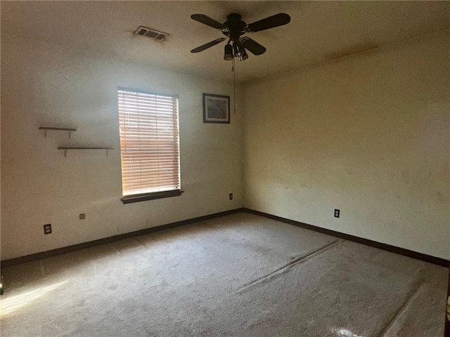 unfurnished room with carpet floors, baseboards, visible vents, and ceiling fan