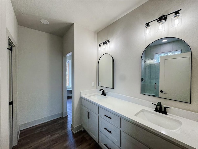 full bathroom featuring baseboards, an enclosed shower, a sink, and wood finished floors