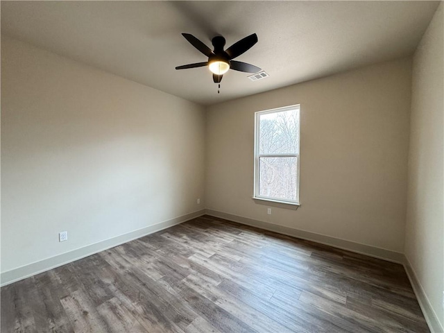 unfurnished room with visible vents, ceiling fan, baseboards, and wood finished floors