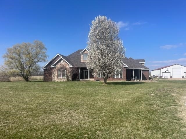 rear view of house featuring a garage and a yard