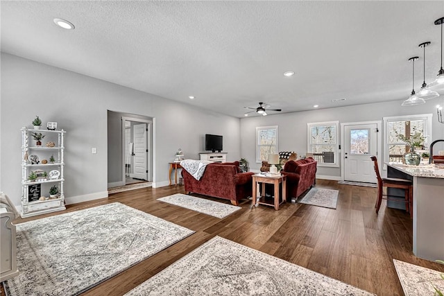 living room featuring recessed lighting, baseboards, dark wood-style floors, and a ceiling fan