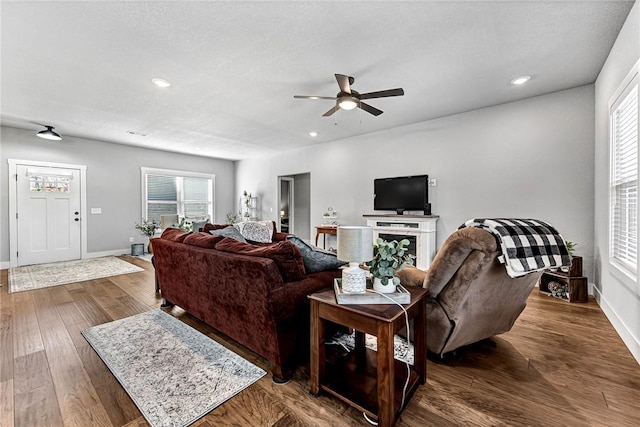 living area featuring baseboards, recessed lighting, a textured ceiling, a ceiling fan, and wood-type flooring