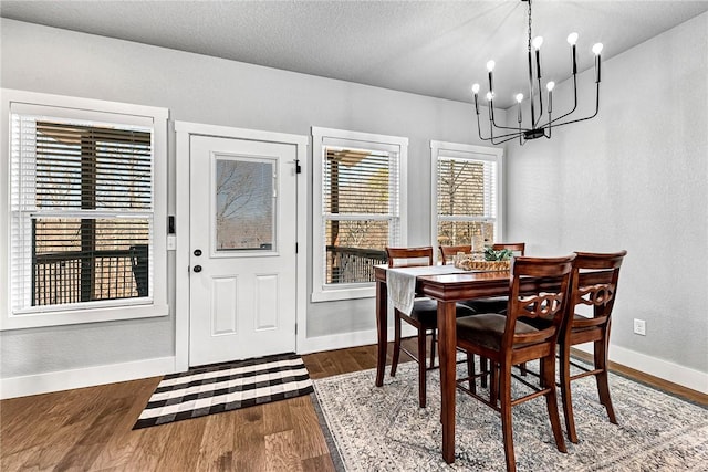 dining area featuring baseboards, dark wood-style flooring, and a chandelier