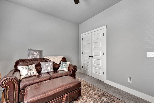 carpeted living area featuring baseboards