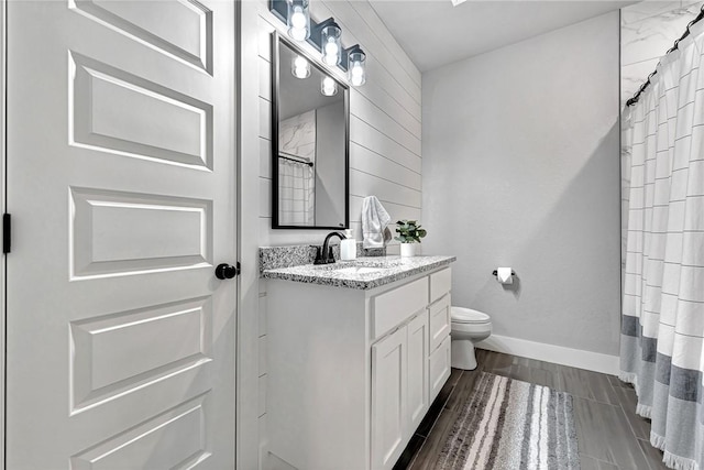 bathroom with vanity, a shower with curtain, baseboards, wood tiled floor, and toilet