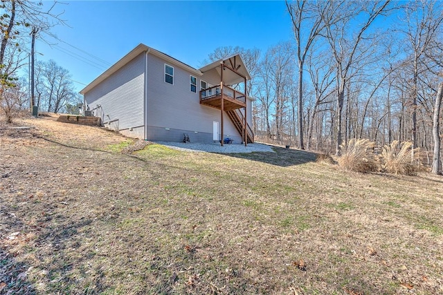 rear view of property featuring stairway, a lawn, and a wooden deck