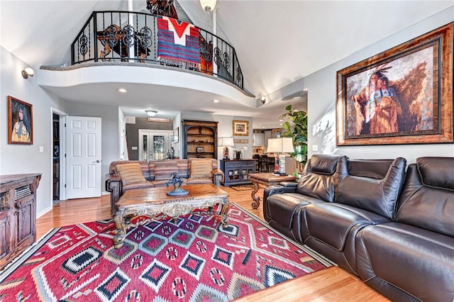 living area featuring a high ceiling, wood finished floors, and baseboards