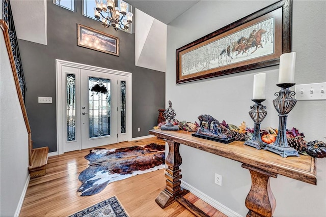 entryway featuring an inviting chandelier, baseboards, and wood finished floors