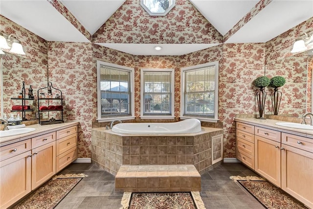 bathroom with vaulted ceiling, two vanities, a sink, and wallpapered walls