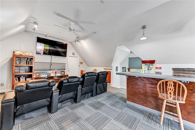 carpeted home theater room featuring vaulted ceiling, a ceiling fan, rail lighting, and baseboards