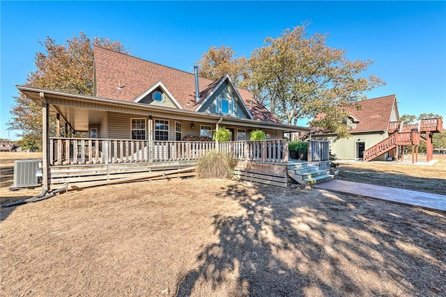 view of front of house with a shingled roof and central air condition unit