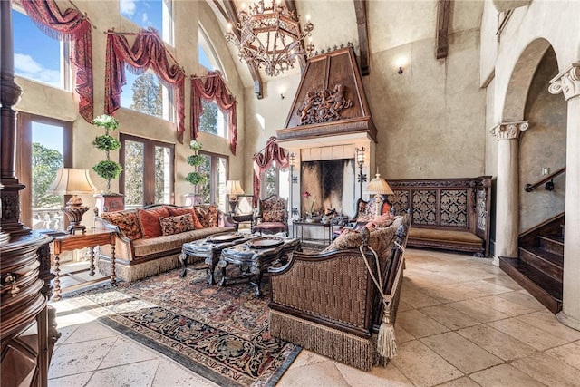 2 S Samoset Ct, Rogers, AR 72758 - living room with a towering ceiling, arched walkways, stone tile flooring, a chandelier, and stairs