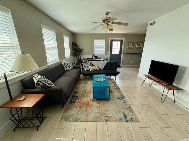 living room featuring a wealth of natural light, visible vents, and wood tiled floor