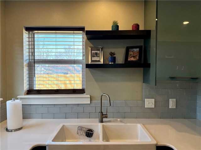 kitchen featuring light countertops, a sink, and decorative backsplash