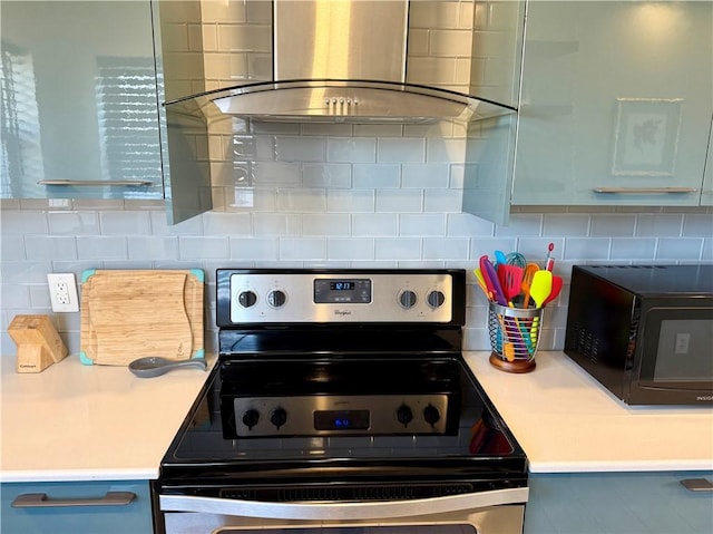 kitchen featuring tasteful backsplash, stainless steel electric range oven, ventilation hood, light countertops, and black microwave