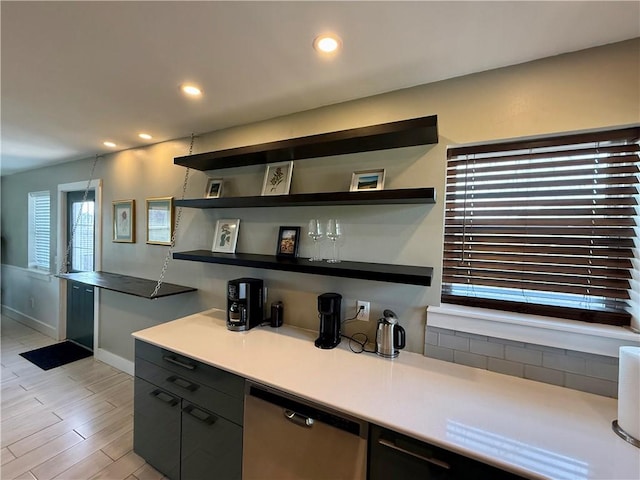 kitchen with open shelves, recessed lighting, light countertops, stainless steel dishwasher, and light wood-style floors