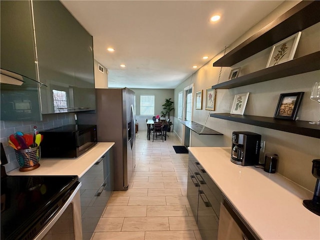 kitchen with decorative backsplash, modern cabinets, appliances with stainless steel finishes, open shelves, and recessed lighting