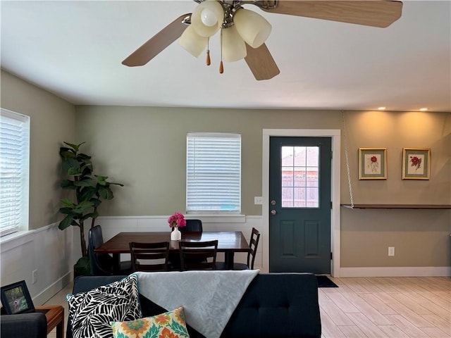 dining room featuring baseboards, a ceiling fan, and wood finished floors